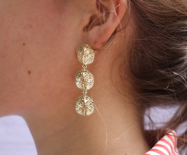 Girl wearing alligator scute triple drop earrings in gold by Gogo Jewelry