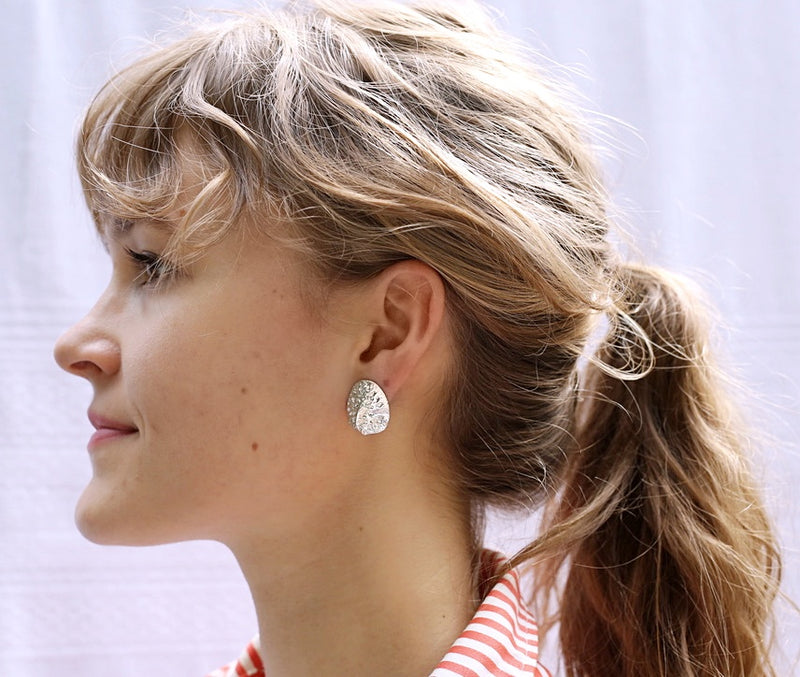 Girl wearing large silver alligator scute earrings by Gogo Jewelry