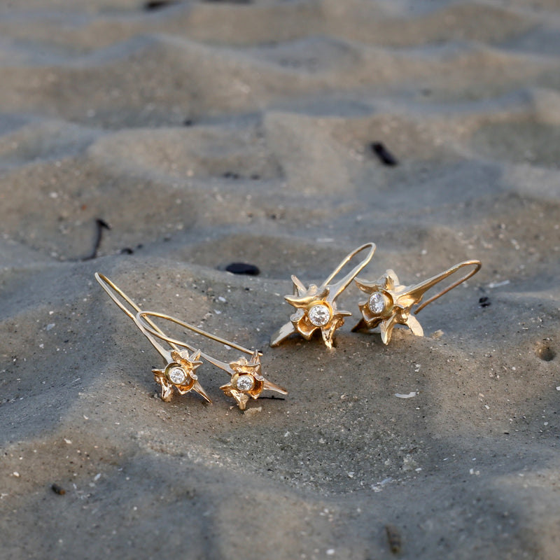 14k gold rattlesnake vertebrae earrings with white diamond small and large on beach