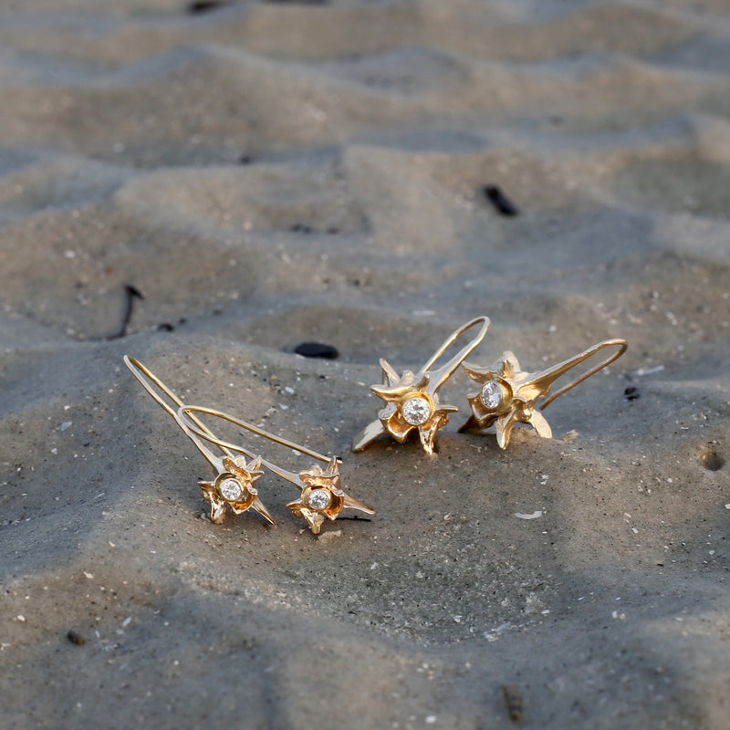 14k gold rattlesnake vertebrae earrings with white diamond small and large on beach