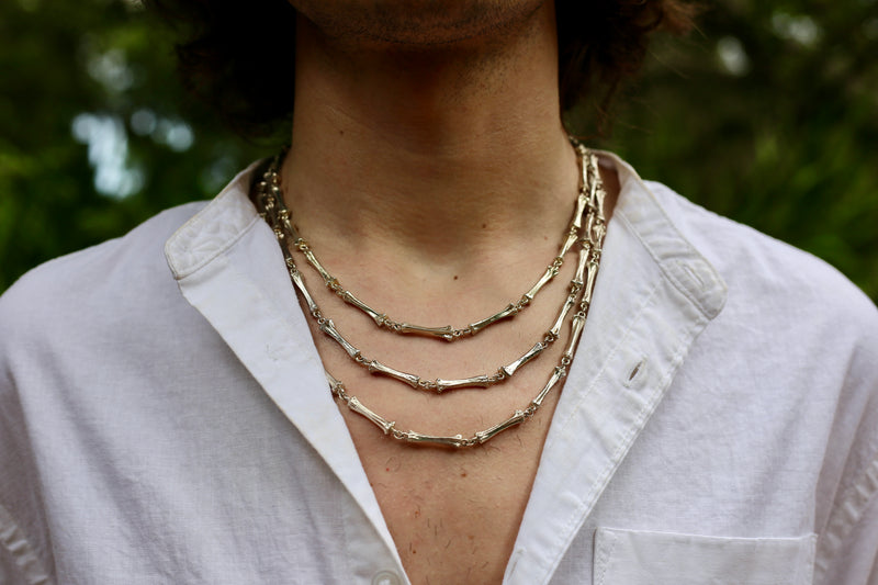 three layered alligator toe bone necklaces on male model gogo jewelry