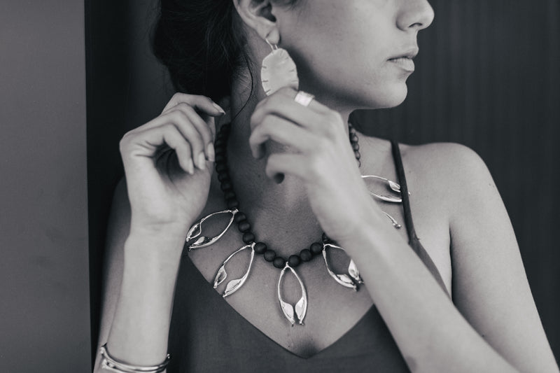 woman modeling rattlesnake jawbone multi necklace in black and white photo