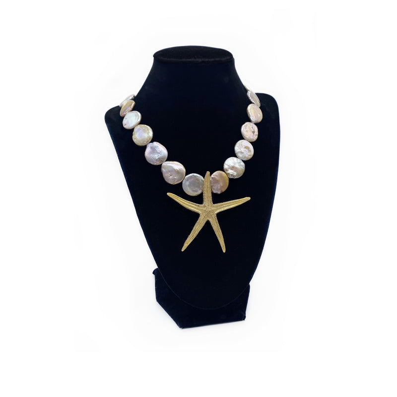 extra large gold starfish gogo jewelry enhancer on coin pearl necklace strand on black velvet jewelry stand 