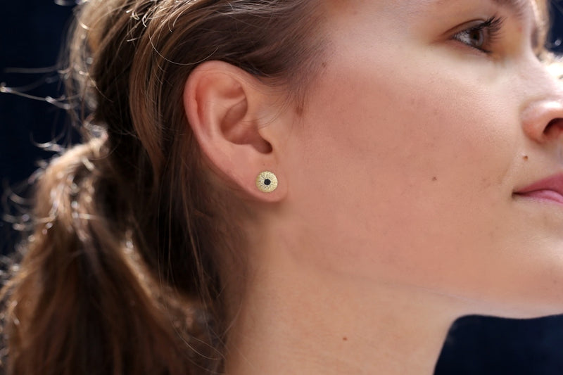 small gold vermeil sea urchin earrings with black onyx on brunette female model