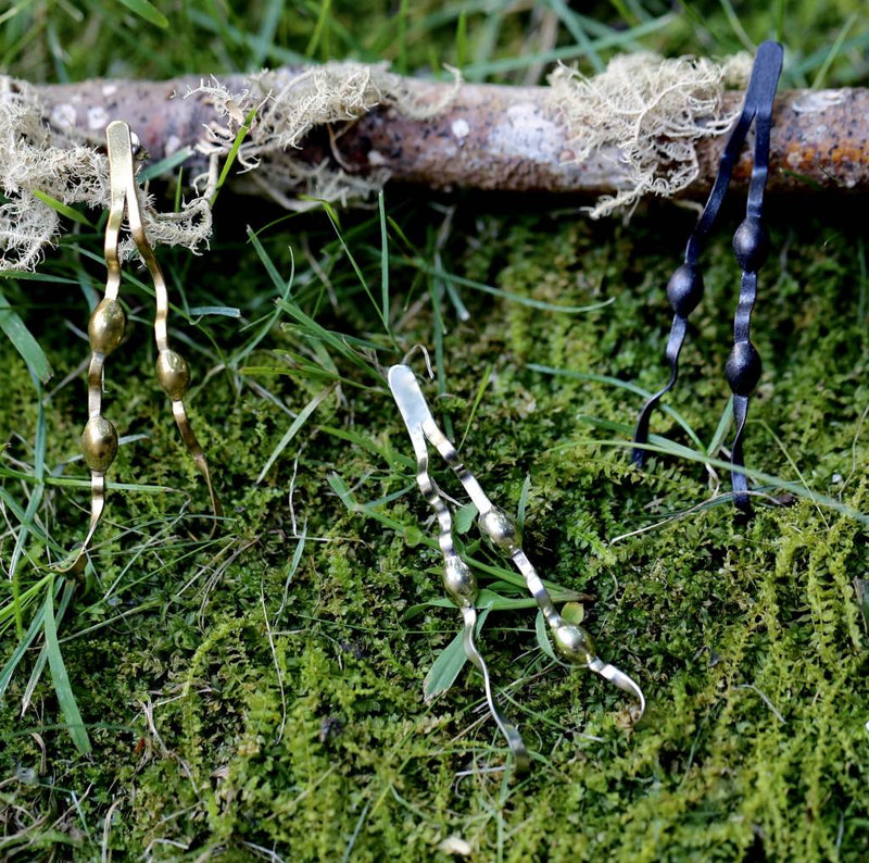 alpaca tumbaga and oxidized new england seaweed post earrings on moss background